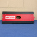 Red and black 'Kwik Passer' product on a blue surface with a tiled wall background