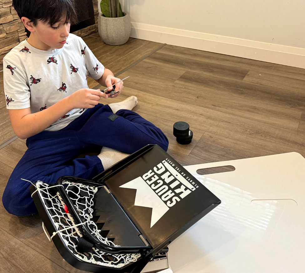 Child sitting on the floor with a laptop and stationery items in a room.